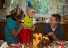 Toddler with party hat eating cake