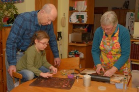 Grandparents making cookies with granddaughter