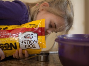 Girl pouring chocolate chips into cup